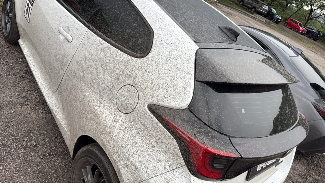 GR Yaris ZUSS livery rear quarter view, dirt-covered after a track session